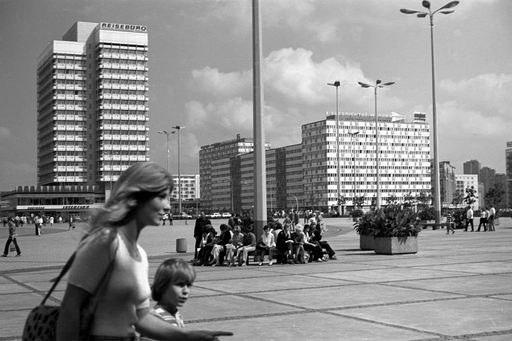 Black and white photo of Alexanderplatz in the 70s. In the foreground, a woman and child are walking past.